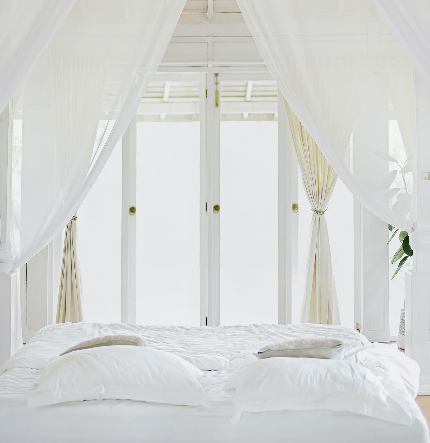 brightly lit bedroom with white linens